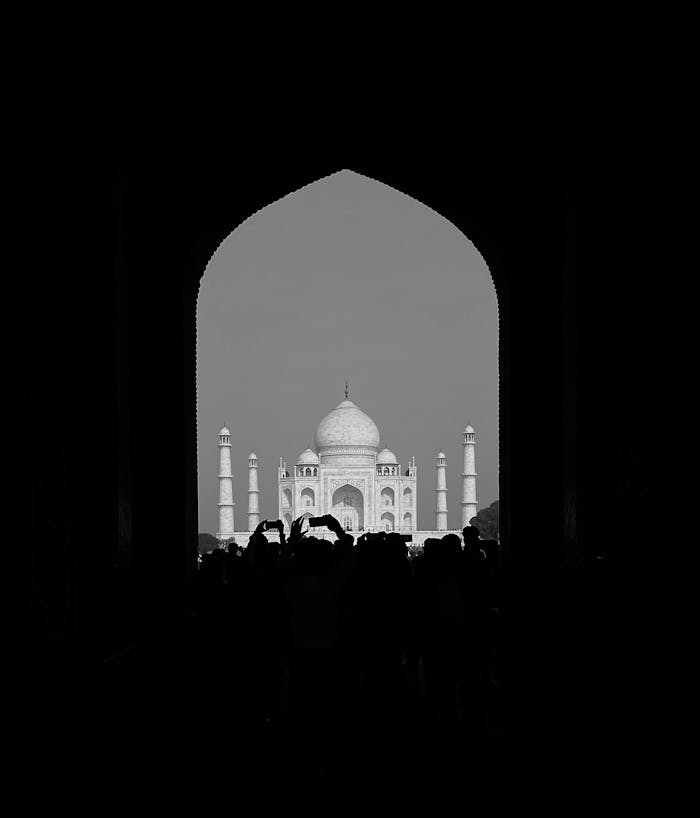 A dramatic silhouette framing the iconic Taj Mahal in Agra, India.